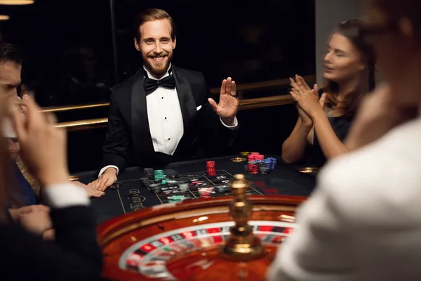 A confident dealer surrounded by casino chips inviting players to access their GOOD111 account, reflecting quick and easy login options.